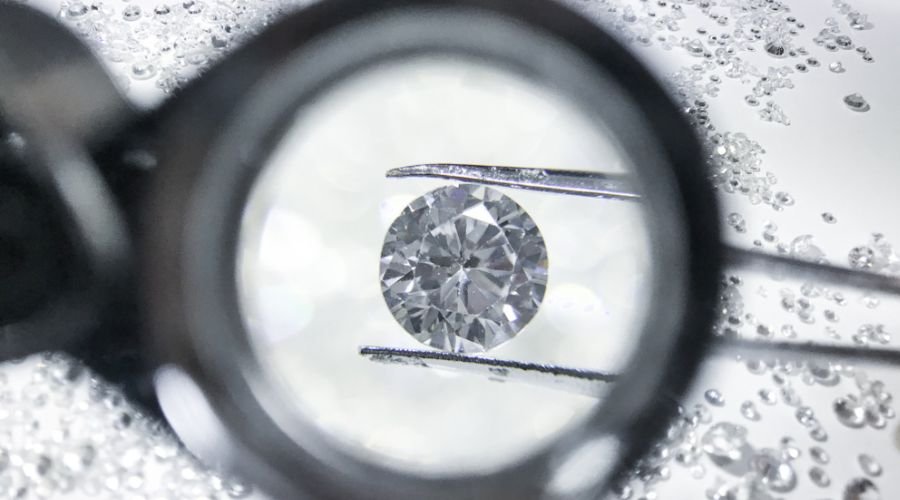 close up of a diamond on a tweezer when viewed under a loupe