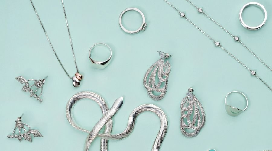 different silver colored jewelry on minimalist mint green background