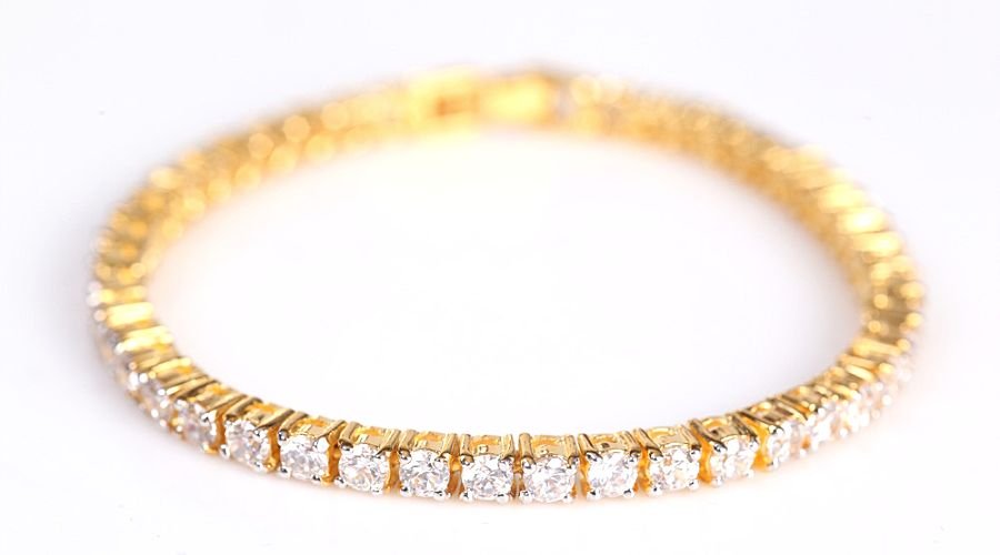 a yellow gold diamond tennis bracelet isolated on whit background